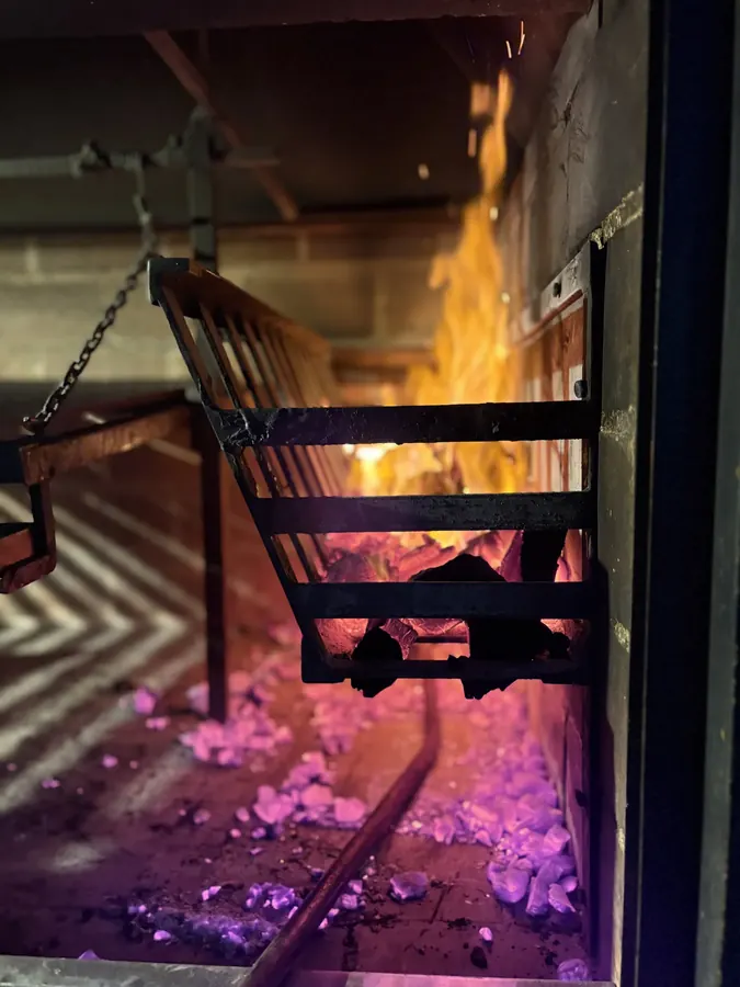 Parrilla con llamas y carne cocinándose