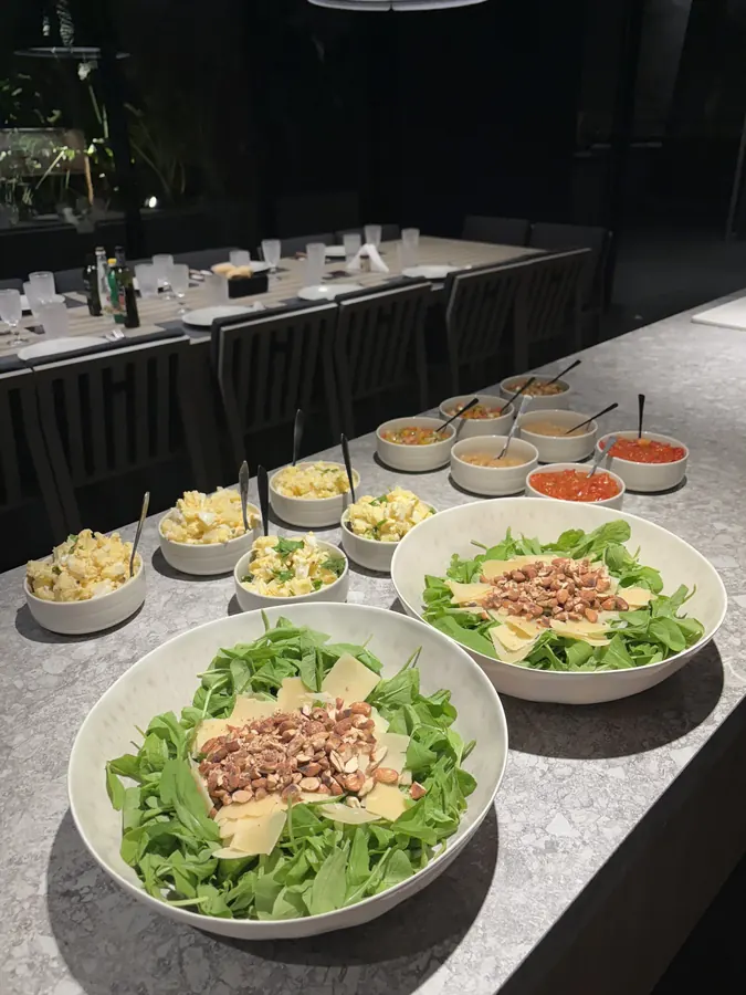 Salad bar con bowls de ensaladas y acompañamientos en un evento de Asarte